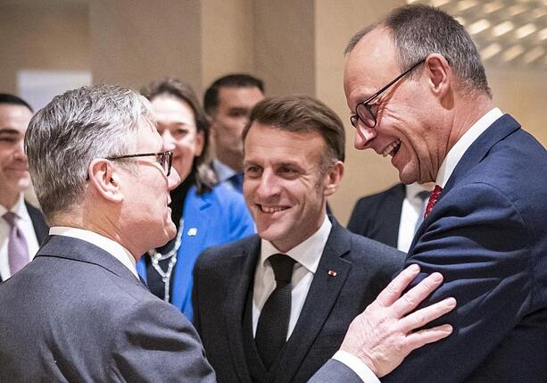 Bild vergrößern: Merz plaudert mit Starmer und Macron beim Abendessen